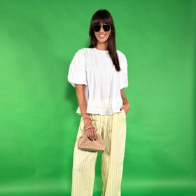 Oblíbený outfit stylistky Nikoly Markové - bílá halenka, pohodlné a lehké kalhoty s proužkem a k tomu hnědé doplňky. 