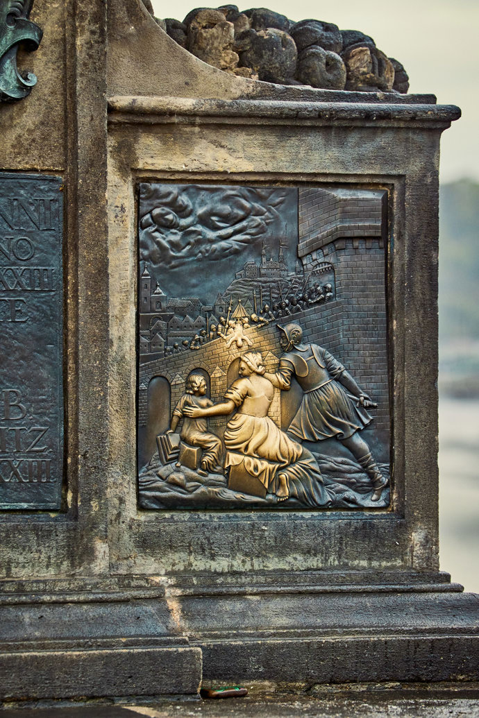 Detail podstavce sochy světce Jana Nepomuckého na Karlově mostě.