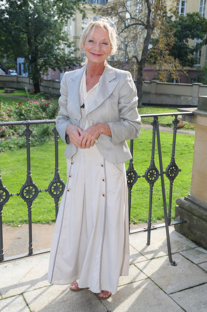 Vilma Cibulková oblékla bílou halenku a širokou béžovou sukni zdobenou řadami knoflíčků. Komplet doplnila šedým sáčkem a sandálky.