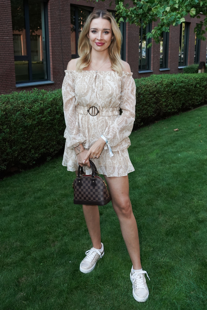 Nikol Šáchová oblékla béžové romantické šaty se spadanými ramínky, které přepásala, a vše doplnila kabelkou Louis Vuitton a bílými teniskami. 