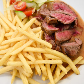 Hovězí flank steak, pepřová omáčka a hranolky.