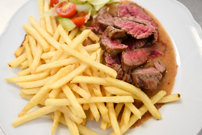 Hovězí flank steak, pepřová omáčka a hranolky.