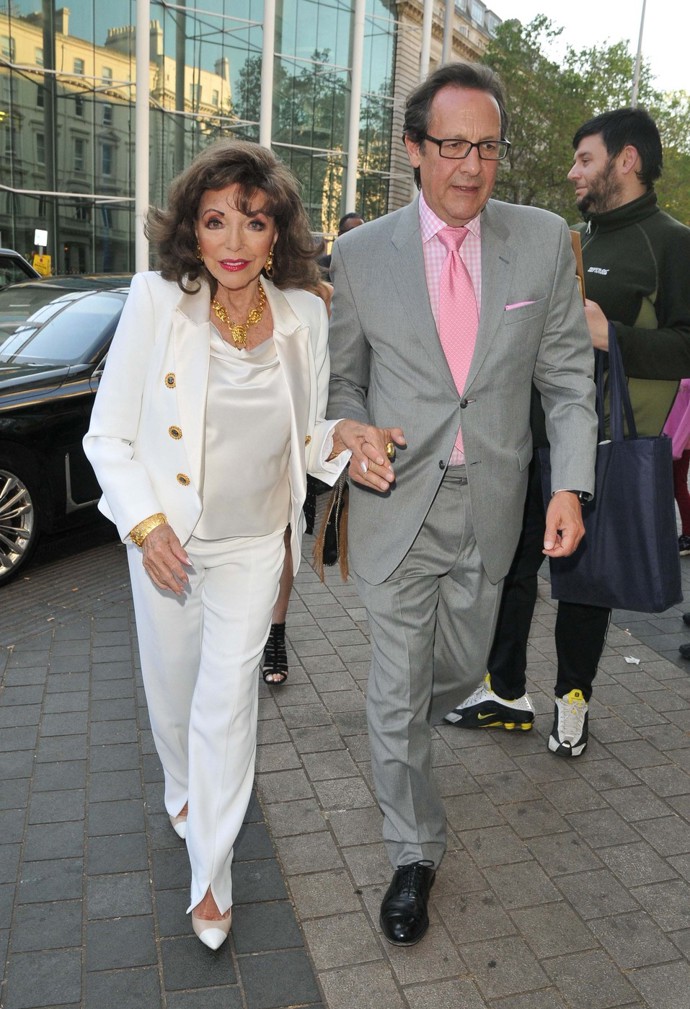 Joan Collins si zachovává elegantní ženský styl, i když nosí kalhoty. Herečka si libuje v luxusních materiálech i třpytivých prvcích a po boku pátého, o 32 let mladšího manžela Percyho Gibsona jen září