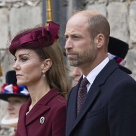 Kabátové šaty doplnila Kate Middleton vínovým kloboučkem Neso z dílny Jane Taylor a náušnicemi s rubínem a diamanty.