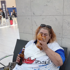 Droběna si na lavičce vychutnává celé kuře a pivo.