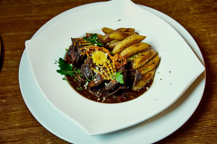 Zajíc na černo s mandlemi, sušenými švestkami a bramborovými šulánky.