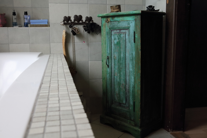 V koupelně je krásná, stará repasovaná skříň.