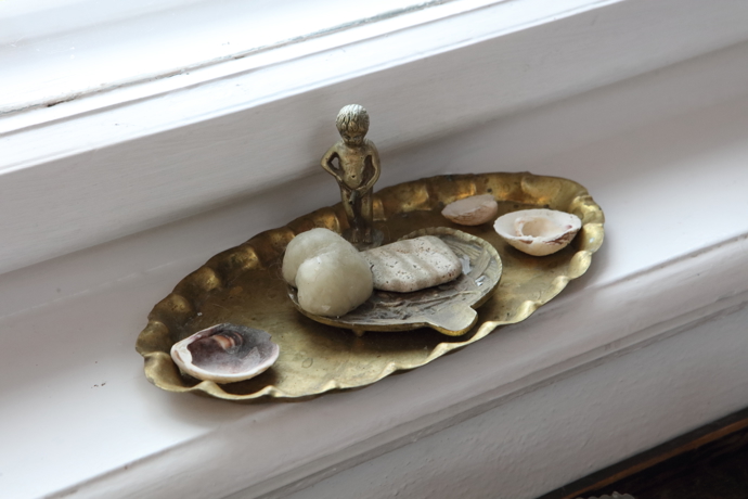 Cínový chlapeček a miska zdobí parapet.