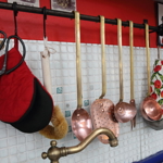 Kuchyni barevně dominuje červená zeď a s ní sladěné doplňky, například červená chňapka.