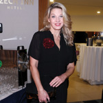 Herečka a moderátorka Sabina Laurinová oživila černý outfit červenou květinovou broží.