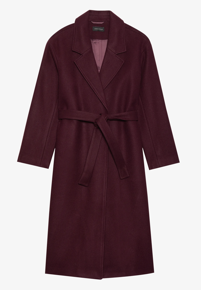 Po vzoru Lucie Borhyové můžete zkusit kabát se zavazovacím páskem. Například tento vínový kousek pořídíte u značky Anna Field za 2020 Kč.