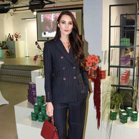 Modelka Kristýna Schicková se proužkovaný kalhotový kostým nebojí oživit výrazným barevným akcentem v podobě červené kabelky.