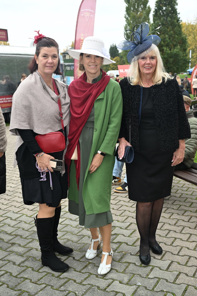 Dámská jízda na Velké pardubické. Vyniká hlavně hráškově zelený kabátek v kombinaci s červeným plédem. 