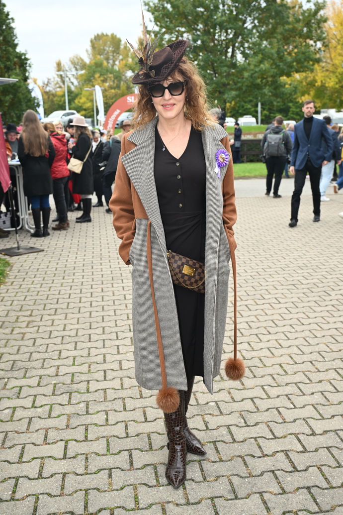 Originální šedo-hnědý kabát skvěle doplnil hnědý fascinátor. 