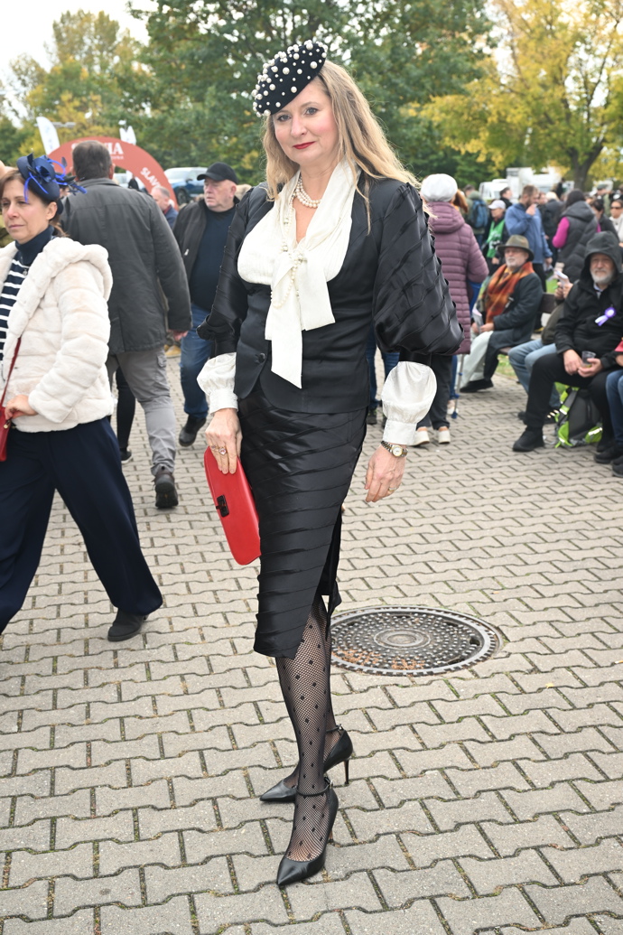 Tato dáma vynesla sněhobílou halenku s výraznou vázankou. Outfit korunovala originálním kloboučkem a rudým psaníčkem. 
