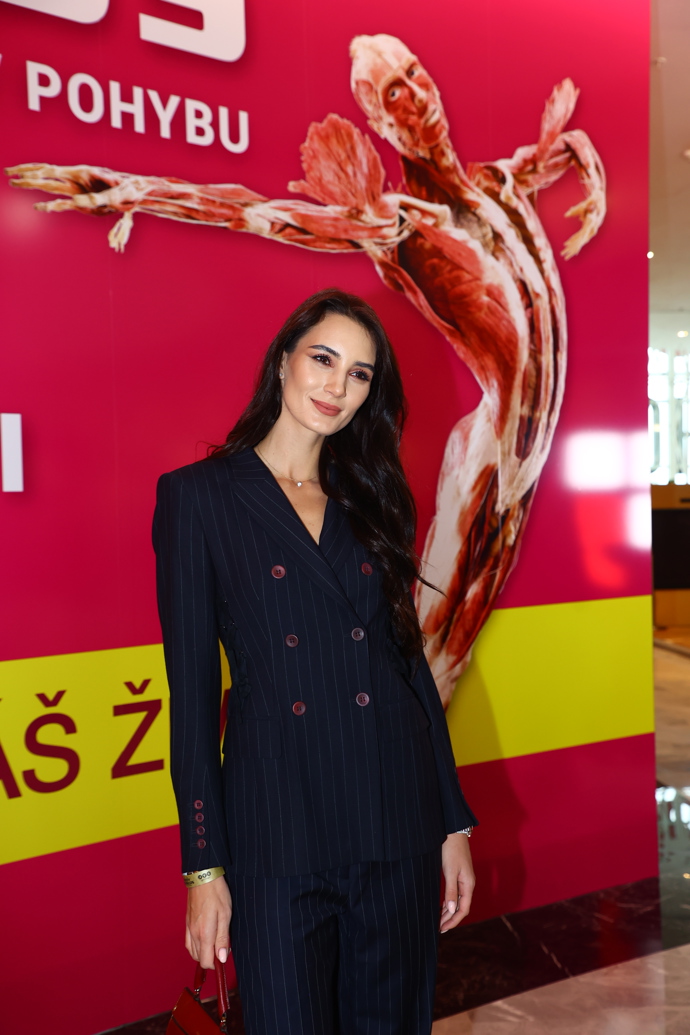 Kristýna Schicková zvolila tmavě modrý kalhotový kostýmek s proužky a s jemným vínovým akcentem v podobě knoflíků.