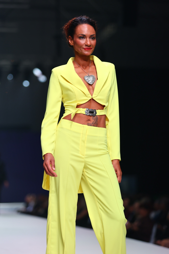 Vynesla žluto-zelený kalhotový kostýmek. 