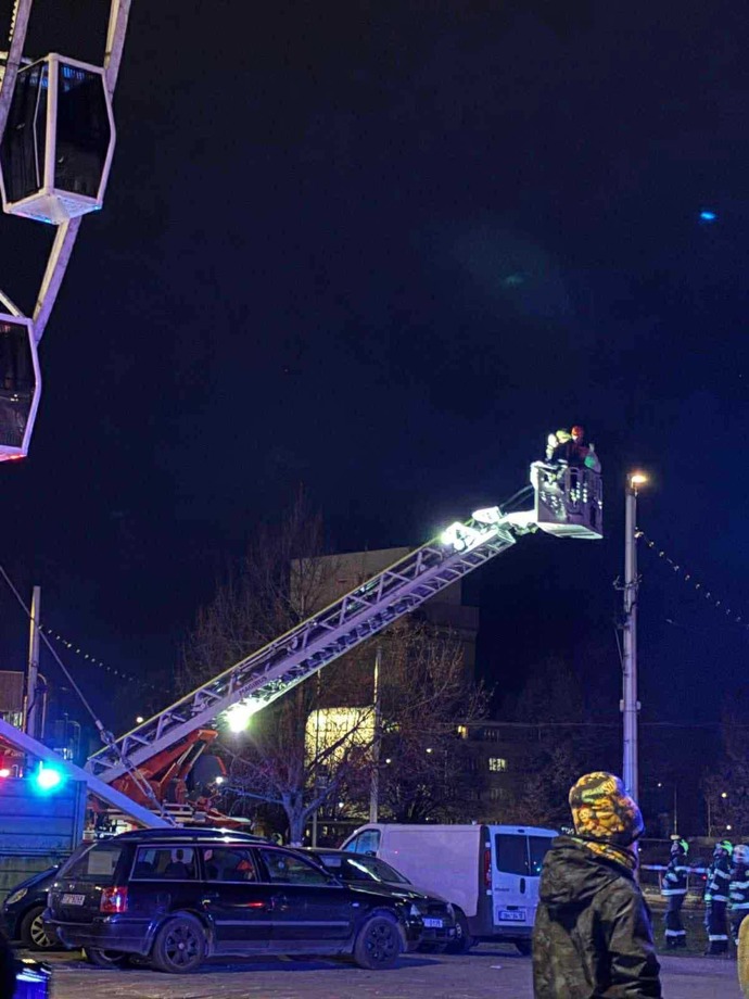Hasiči pomáhají lidem dostat se z kabinek ruského kola.