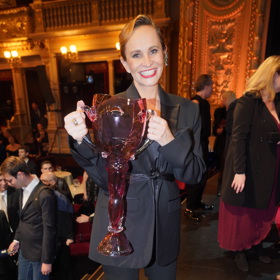 Monika Absolonová oblékla černé smokingové sako v oversize střihu a černé kalhoty a doplnila je o rudé lodičky s uzavřenou špičkou a rudou rtěnku.