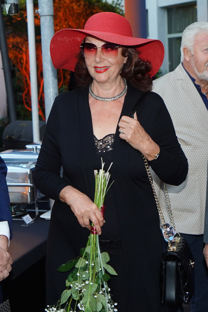 V oblibě má televizní hlasatelka také rudý klobouk s širokou krempou. 