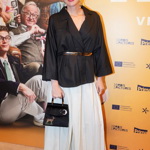 Herečka a moderátorka Michaela Maurerová překvapila elegantní kombinací bílé široké sukně a černého saka kimonového střihu, přepásaného páskem. Jako doplňky zvolila černou kabelku a černé lodičky s uzavřenou špičkou.