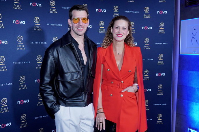 Peter Pecha ozvláštnil koženou bundu slunečními brýlemi s oranžovými skly. Jeho manželka Kateřina oblékla svoji oblíbenou červenou.