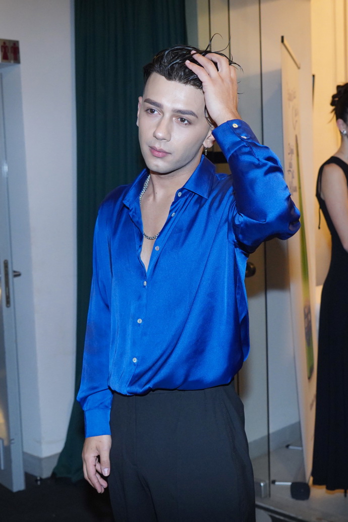 Oblékl jen výraznější saténovou košili. 