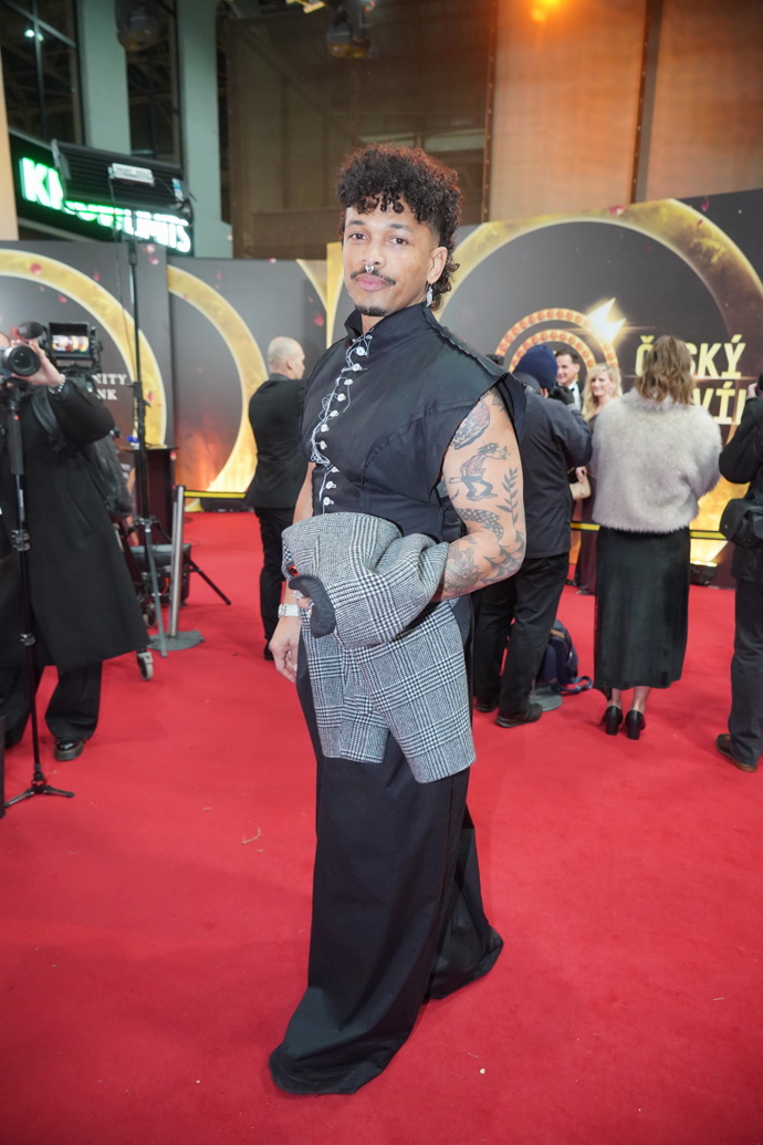 "Ben tentokrát vsadil na své přirozené kudrny ve střihu mullet, který nesluší každému — ale Benovi sedí naprosto dokonale. Působí autenticky, moderně a je vidět, že tenhle look nosí s lehkostí," chválí kadeřník Honza Kořínek. 