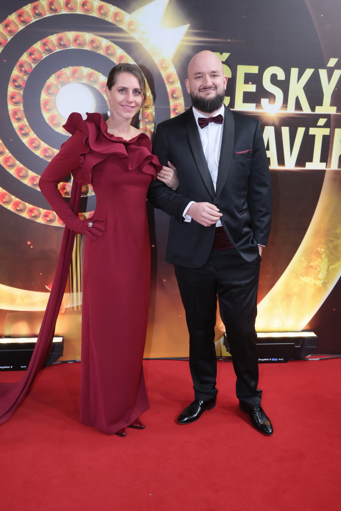 Vínovou róbu od Martiny Pipkové Loudové oblékla manželka Pokáče, Eliška. Doplnila je šperky od Michala Kadaníka. 