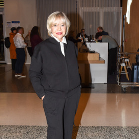 Jana Švandová oblékla mladistvý komplet černých kalhot s kapsami a černé bundičky typu bomber, pod ni oblékla klasickou bílou košili, kterou dopnula až ke krku.