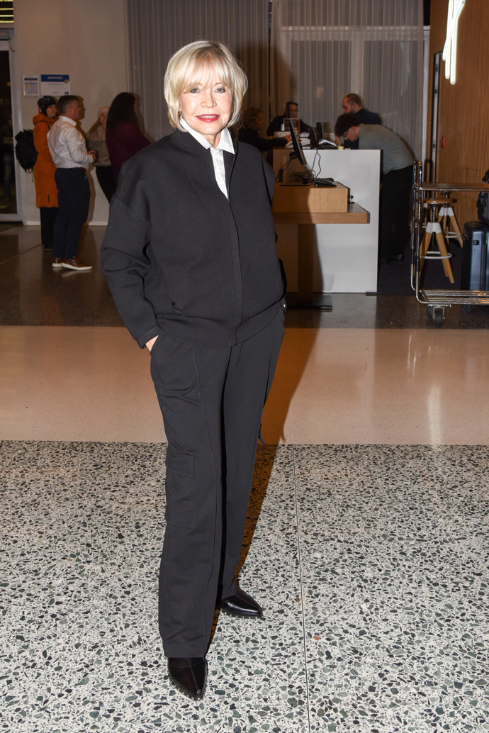 Jana Švandová oblékla mladistvý komplet černých kalhot s kapsami a černé bundičky typu bomber, pod ni oblékla klasickou bílou košili, kterou dopnula až ke krku.