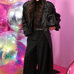 Modelka Aneta Vignerová oblékla černý kožený kabát a kárované kalhoty. 