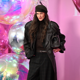 Modelka Aneta Vignerová oblékla černý kožený kabát a kárované kalhoty. 