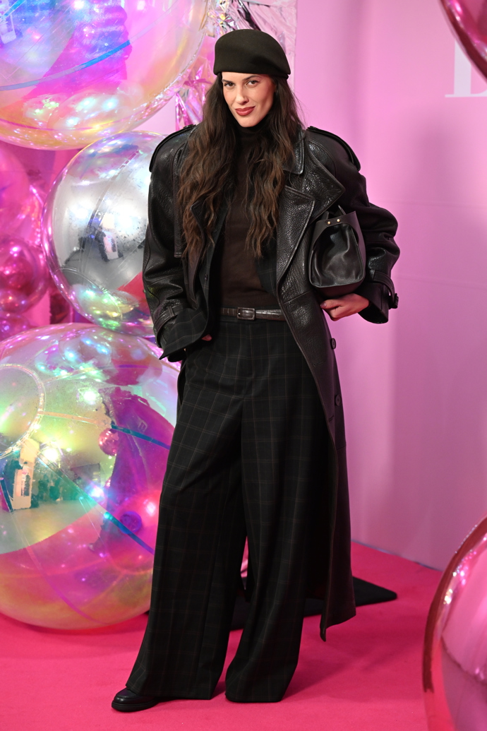 Modelka Aneta Vignerová oblékla černý kožený kabát a kárované kalhoty. 