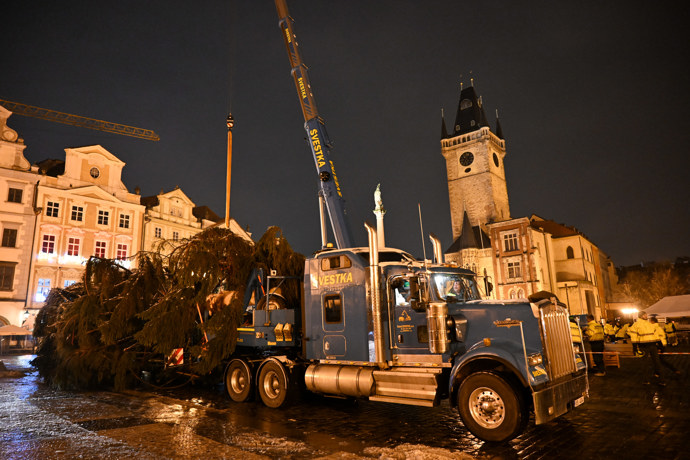 Pracovníci přivážejí vánoční strom na Staroměstské náměstí.