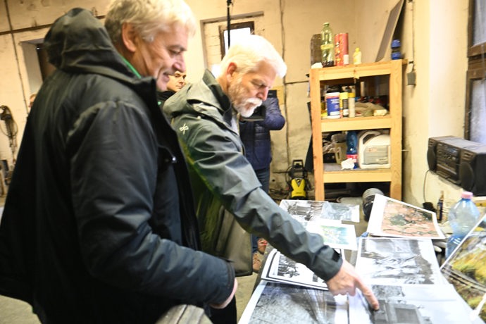 Petr Pavel si prohlíží fotografie v železničním depu.