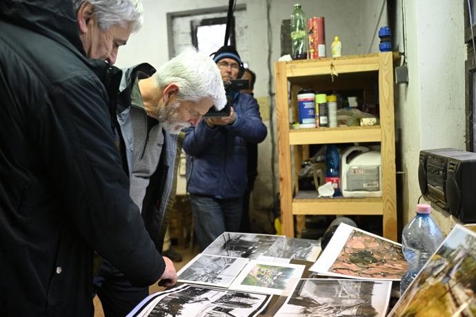 Petr Pavel si prohlíží fotografie v železničním depu.