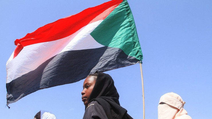 Studenti drží súdánskou vlajku během protestu proti porušování lidských práv spáchaného Jednotkami rychlé podpory (RSF).