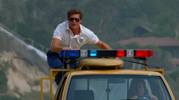 Někdo seriál považuje za kultovní, někdo zase za odpad. Každopádně s 1,1 miliardou diváků se stal, dle knihy rekordů, nejsledovanějším seriálem všech dob. Na snímku David Hasselhoff jako Mitch Buchannon.