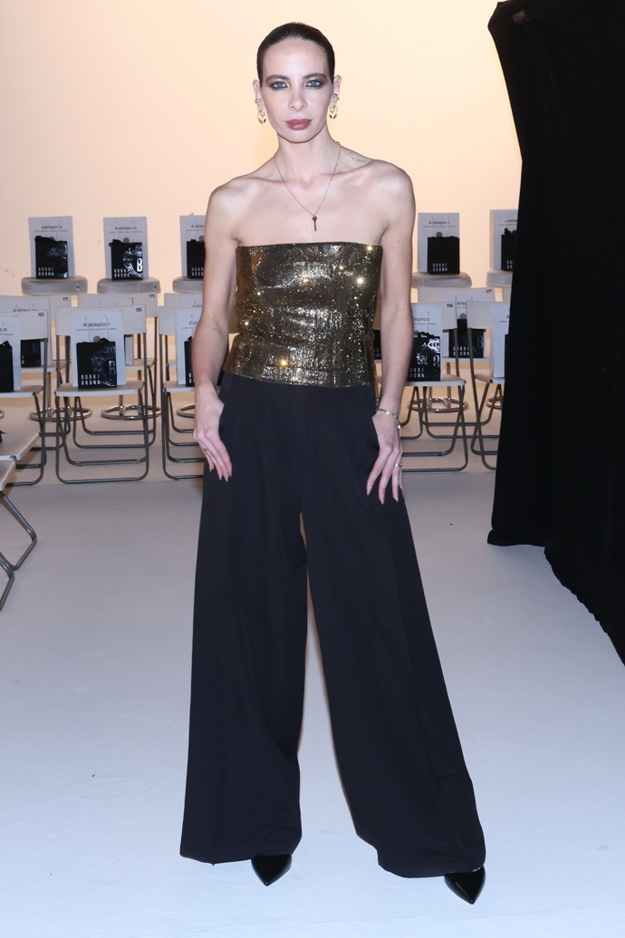 Návrhářka Debbie Brown vítala hosty v širokých černých kalhotách a zlatém metalickém korzetu. 