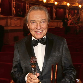 Na první pohled oblek působil obyčejně, ale v detailu je vidět, že byl vzorovaný.