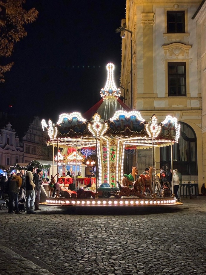 Děti se mohou svézt na krásně osvětleném kolotoči.