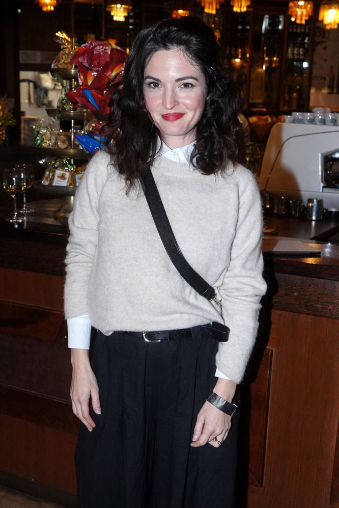 Kristýna Ryška nosí bílou košili pod béžovým svetříkem. 