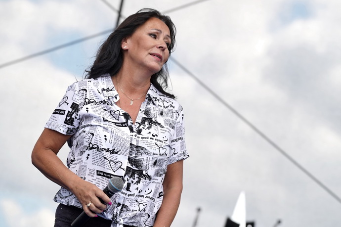 Zazpívala v halence s potiskem novin.