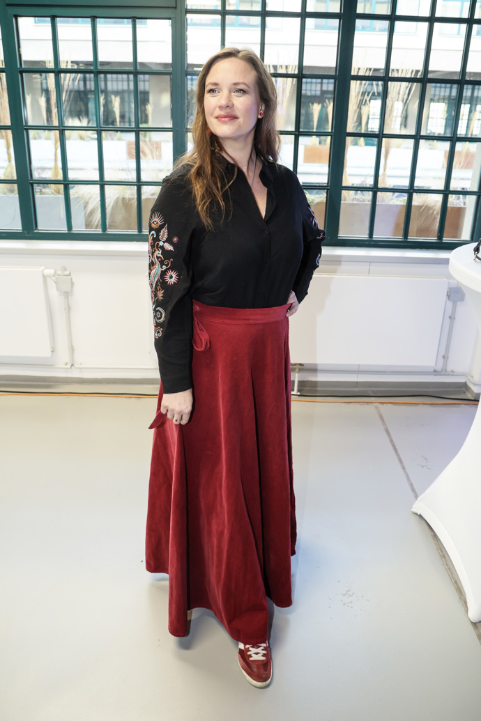 Kristina Leichtová oblékla černý top s krajkou doplněný o rudou skládanou sukni a tenisky. 