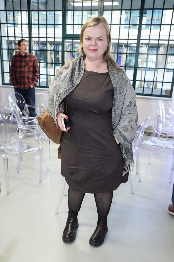 Sabina Remundová oblékla tmavě hnědé šaty a přes ně přehodila šedivý pléd. 