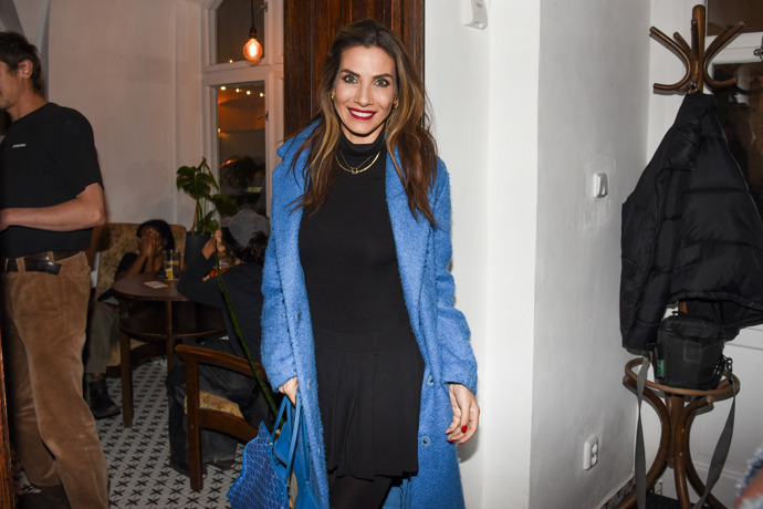 Moderátorka kombinuje kabát s kabelkou.