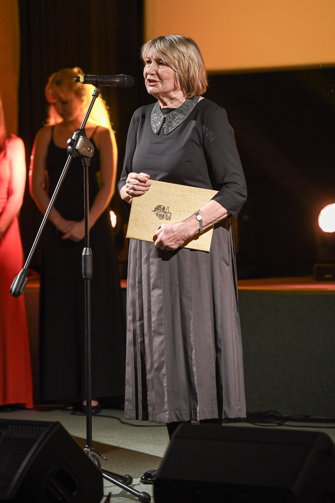 Eliška Balzerová oblékla šedý komplet skládané sukně a topu s ozdobným límečkem.