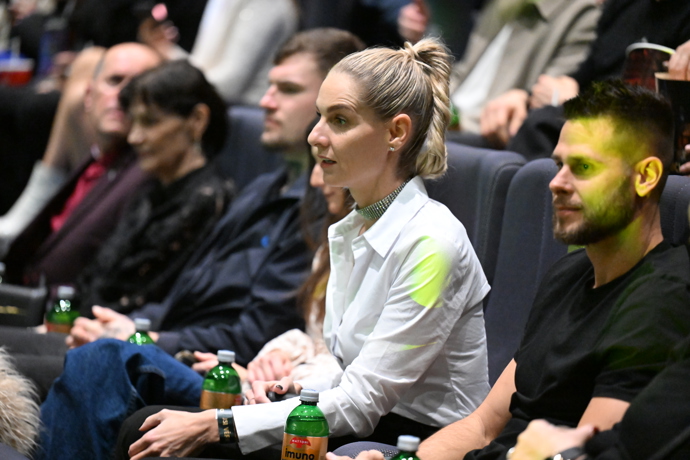 Mia čekající v sálu na odvysílání poslední epizody svého vítězství.