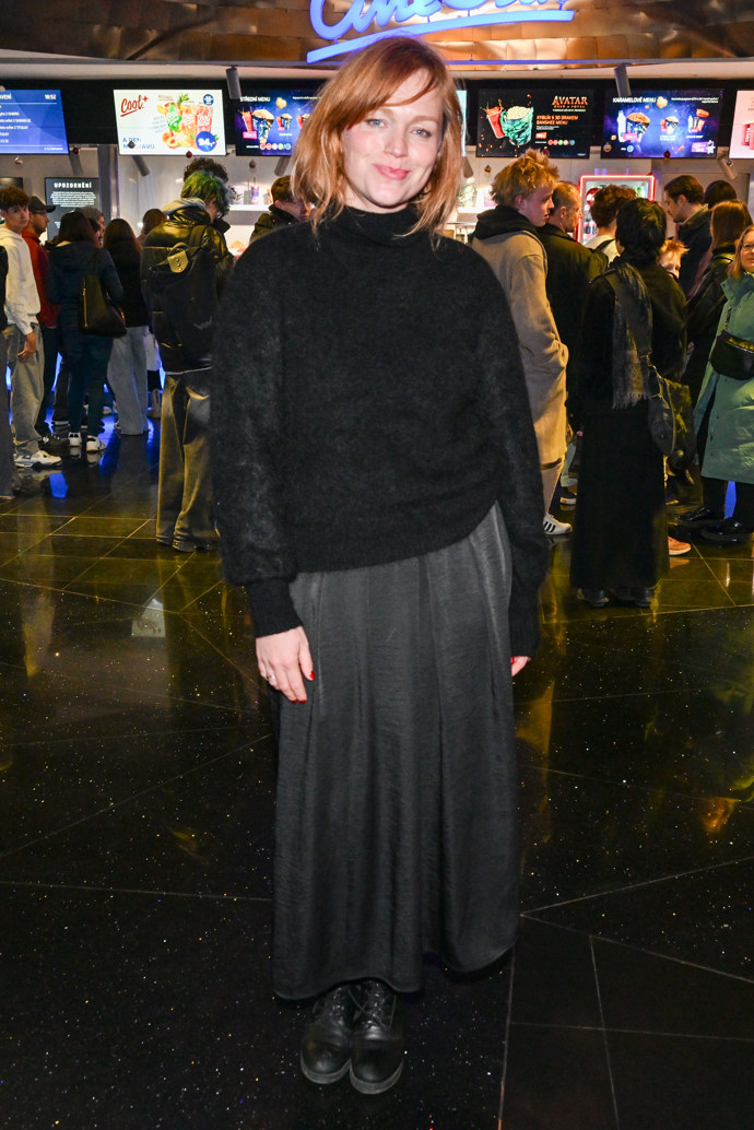 Herečka svetr doplnila šedou nařasenou sukní a pohodlnými černými koženými polobotkami.